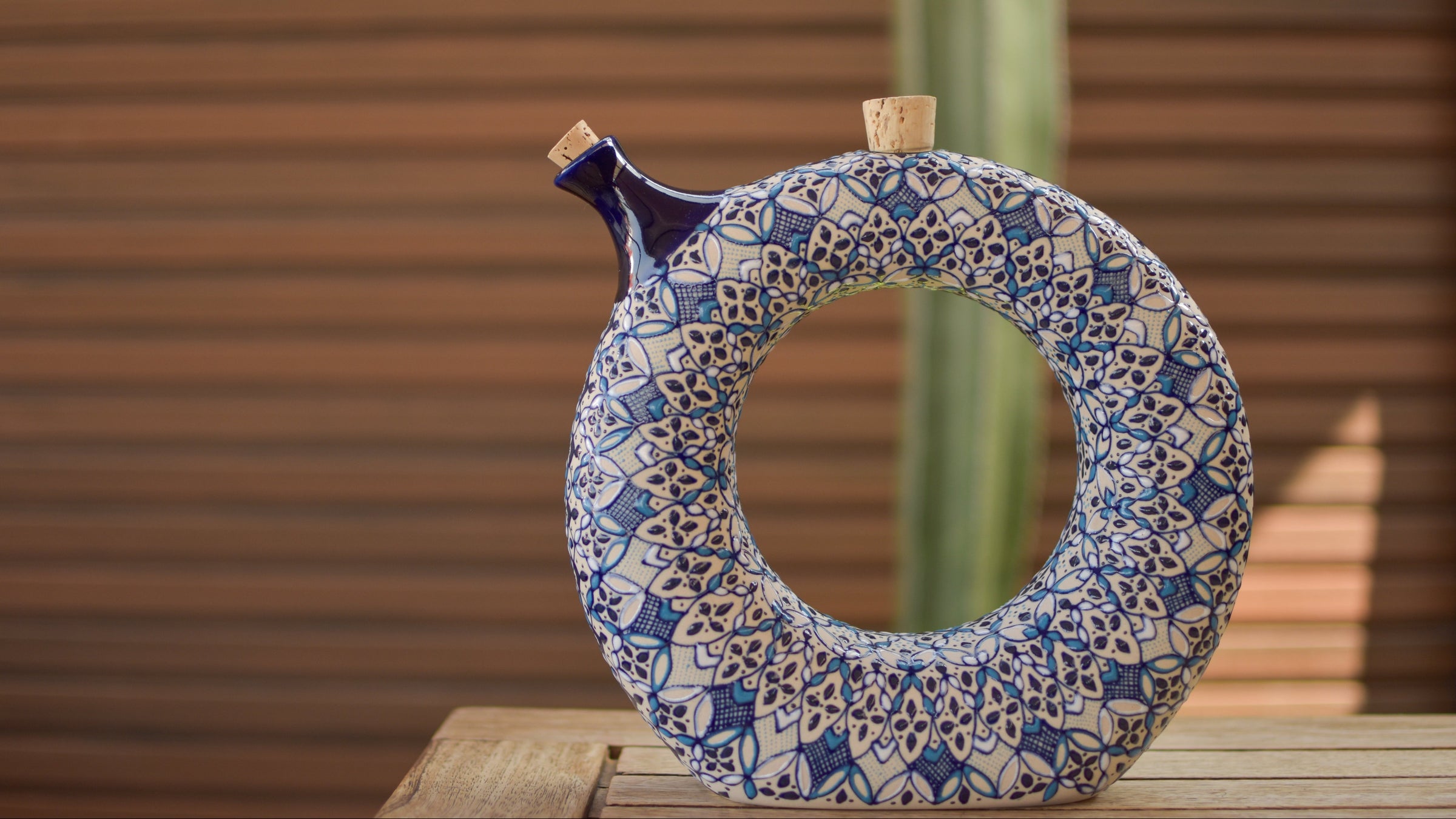 Decorative ceramic mirror with blue and white patterns on a wooden surface.