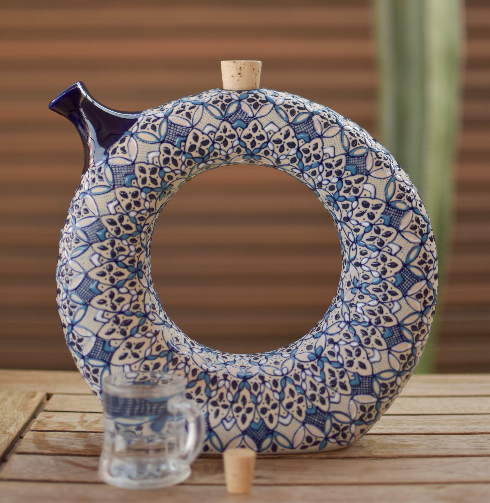 Decorative ceramic item with blue and white pattern on a wooden surface with a blurred background